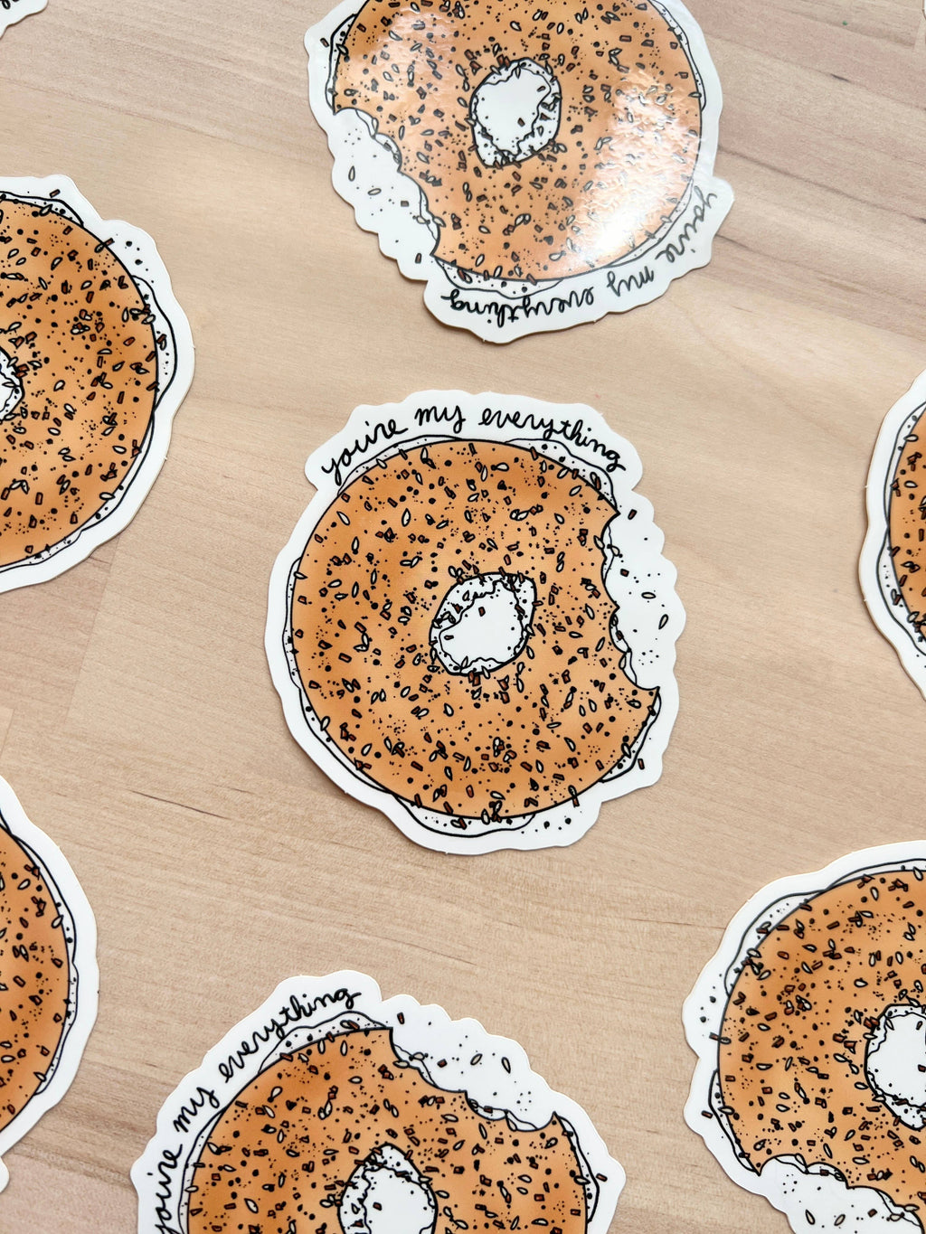 Close up of playful vinyl sticker featuring a bagel with a heartfelt message