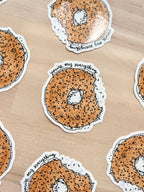 Close up of playful vinyl sticker featuring a bagel with a heartfelt message