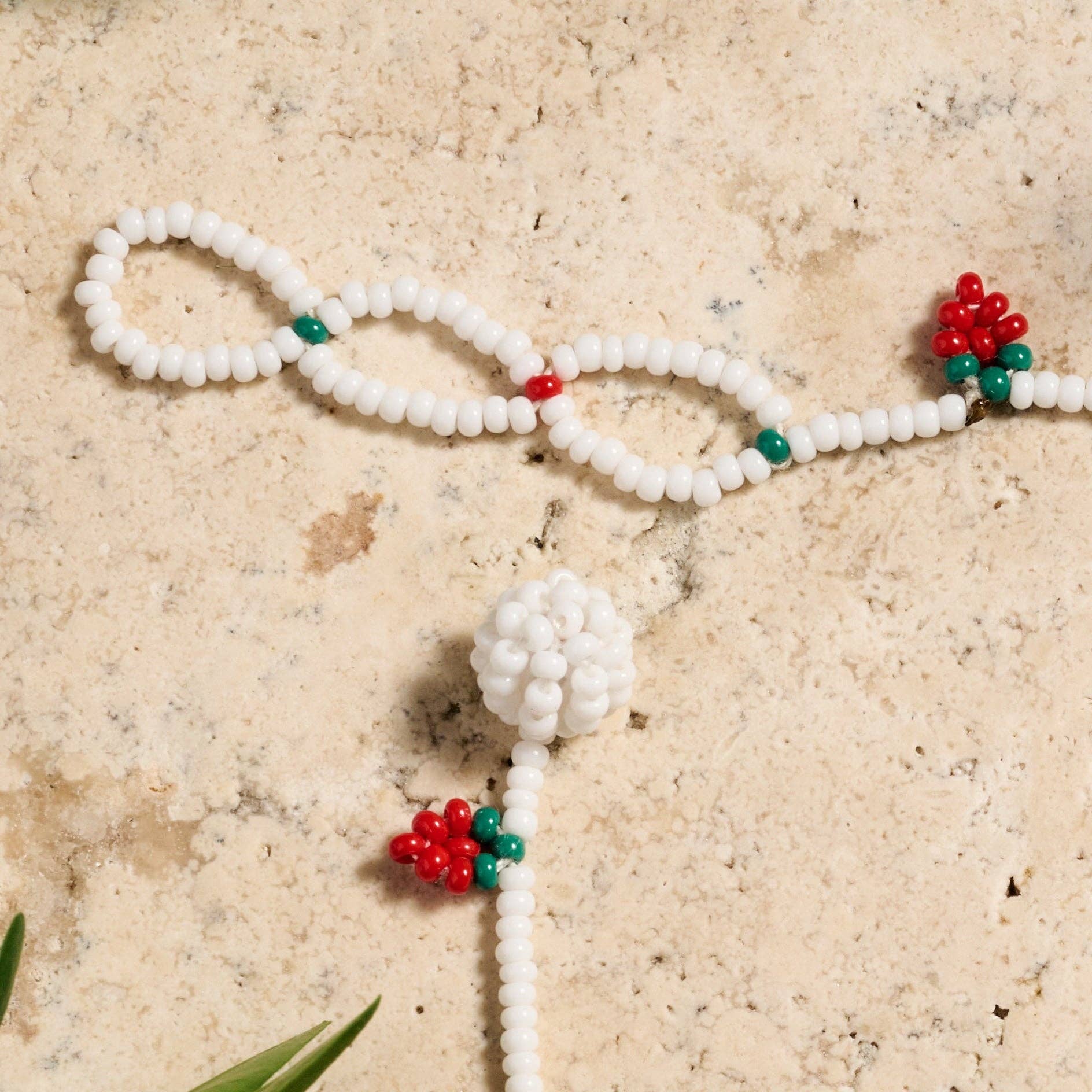 Hand-beaded Taja bracelet with strawberry motif on soft cotton thread, adjustable closure visible