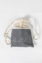 Drawstring bag with 'be still' text on a white background