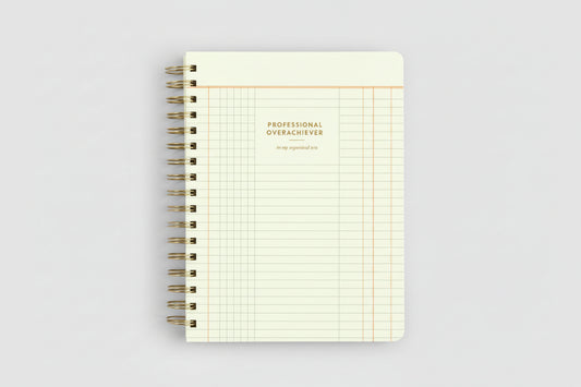 Notebook with grid pattern and 'Professional Overachiever' text on a white background