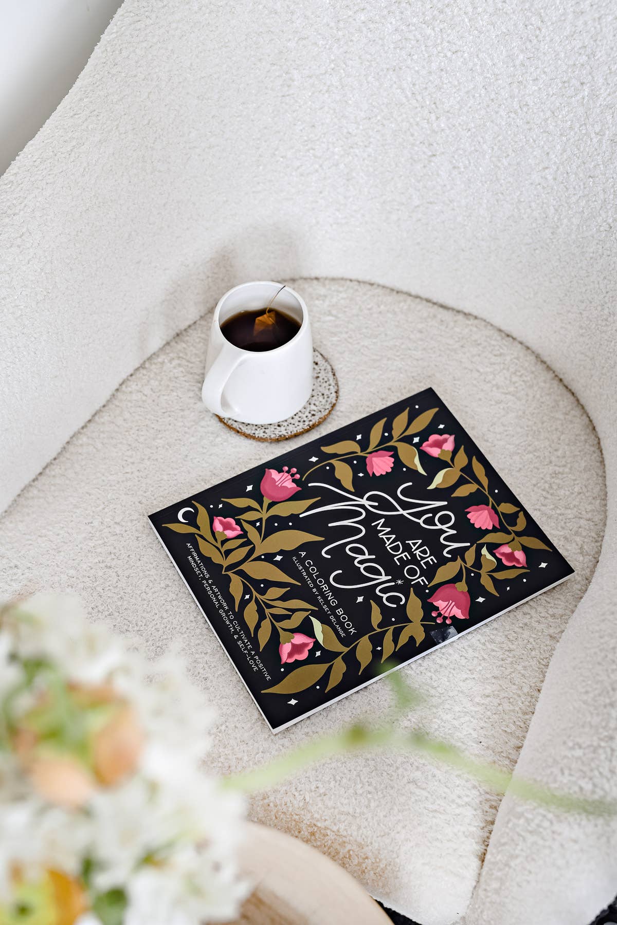 Book titled 'A Year of Magic' on a textured surface with a cup of coffee.