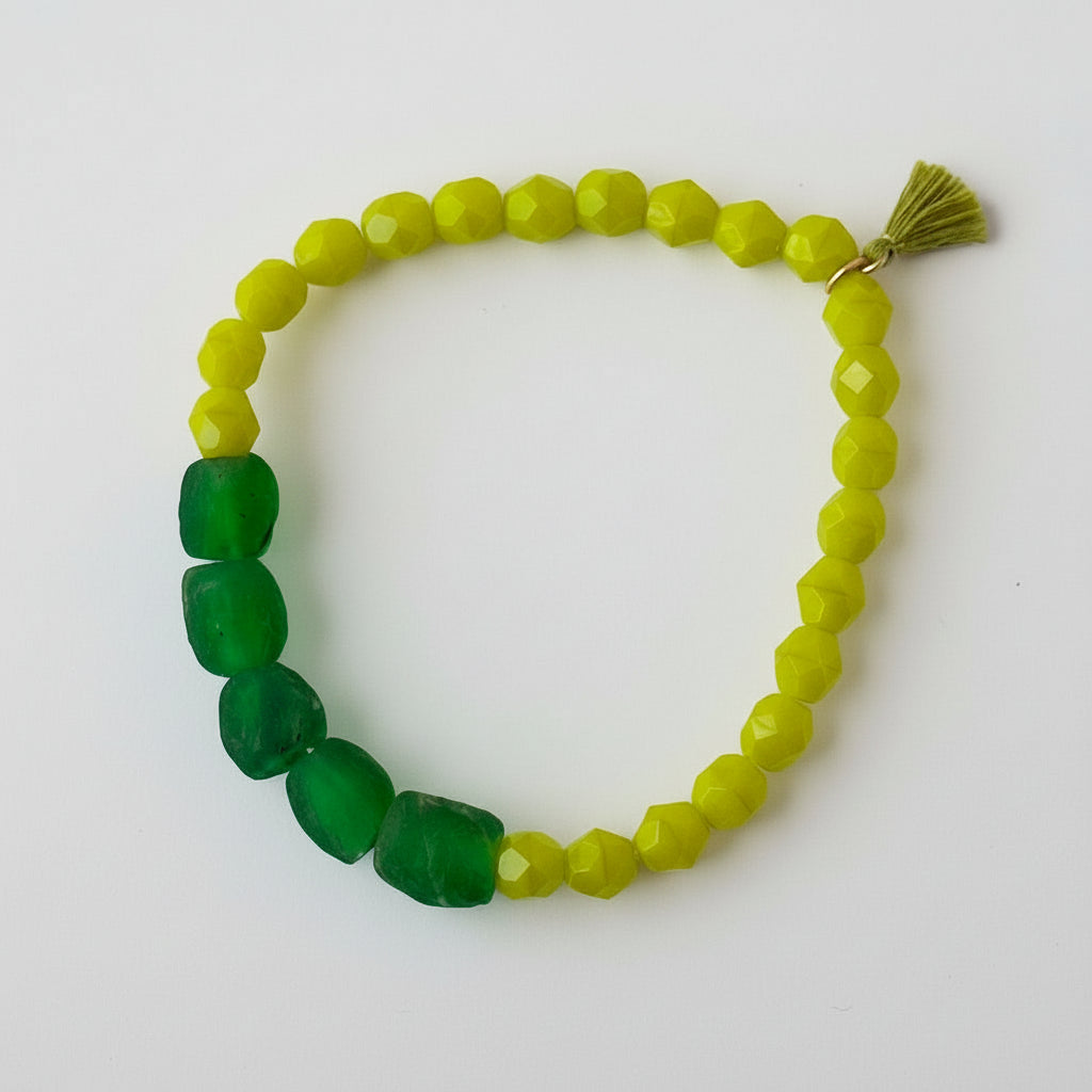 A collection of colorful green beads creating a beautiful bracelet with a tassel.
