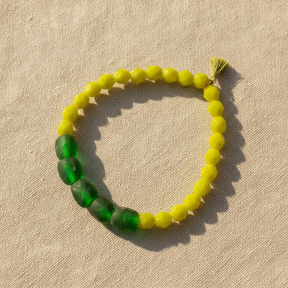 Beaded bracelet with green and yellow beads on a white background