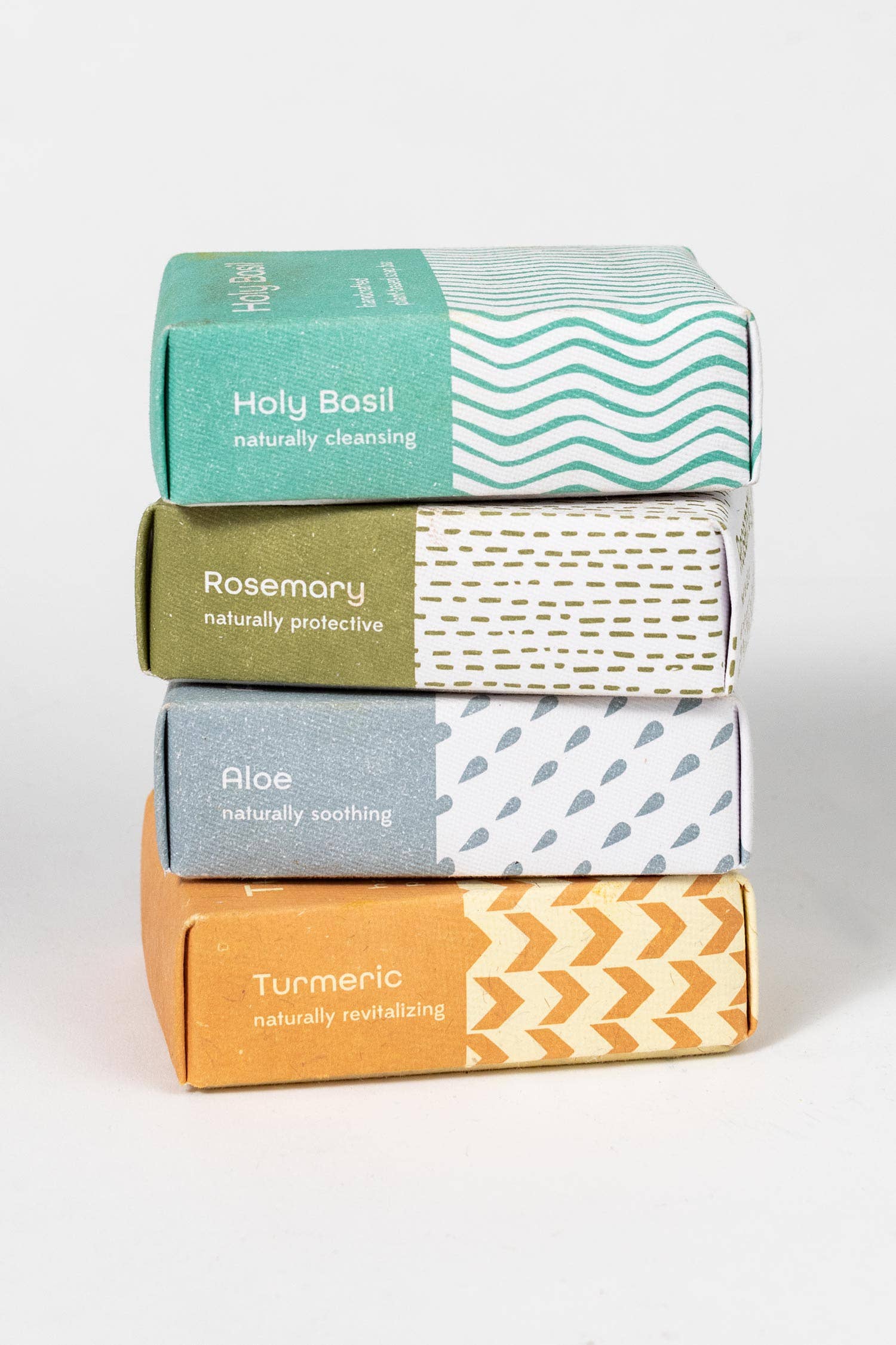 Stack of four boxes with different colored lids and text on a white background