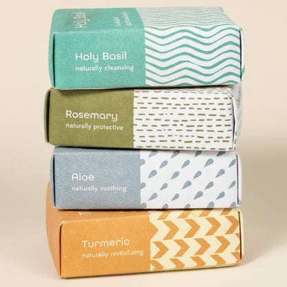 Stack of four boxes with different colored lids and text on a white background