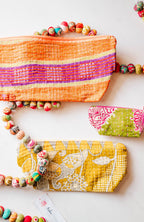 Colorful fabric pouches with bead embellishments on a white background