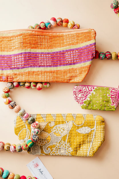 Colorful fabric pouches with bead embellishments on a white background