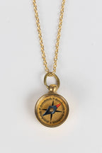 Gold necklace with a compass pendant on a white background