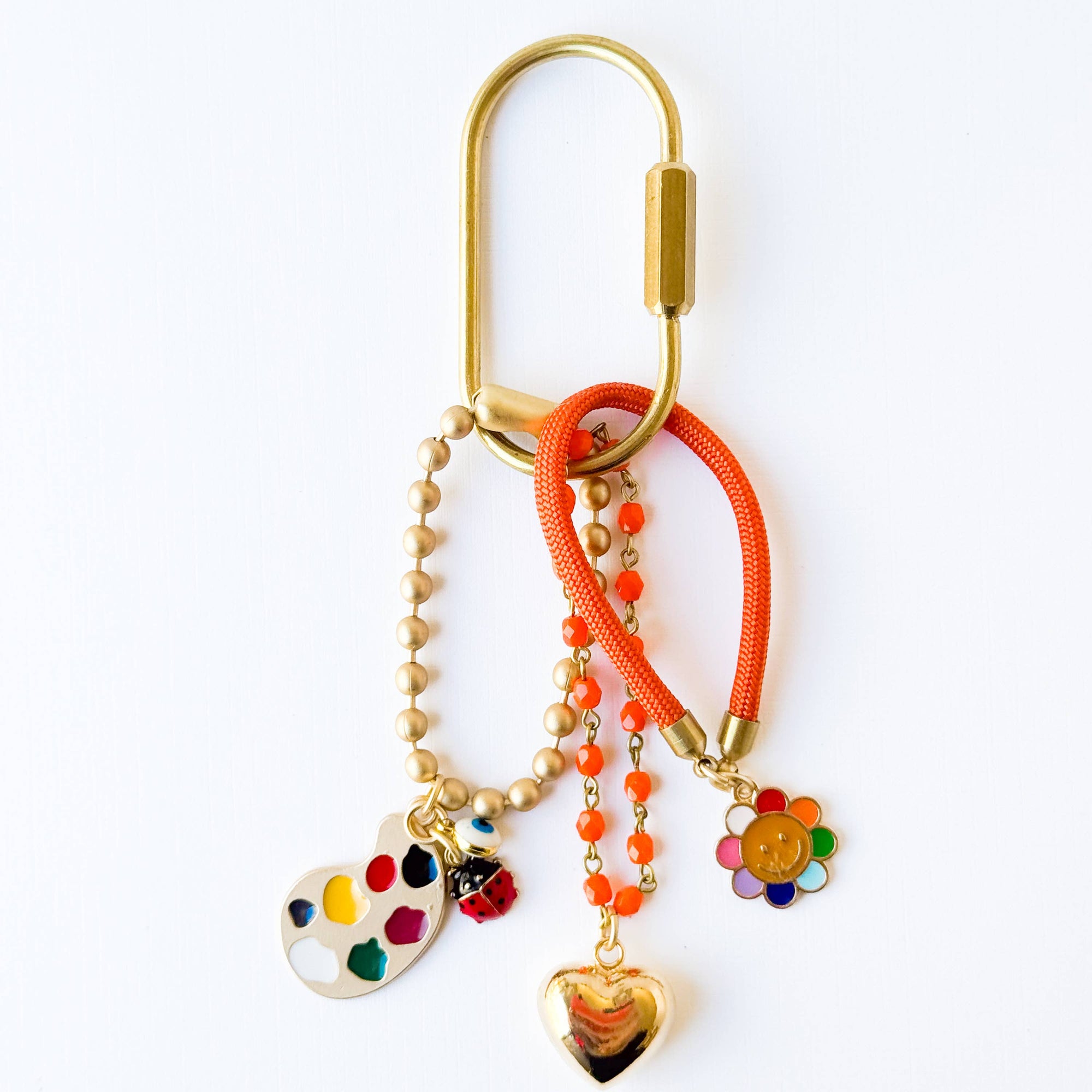 Handmade rainbow bag charm keychain with green bead accents and bold colorful charms