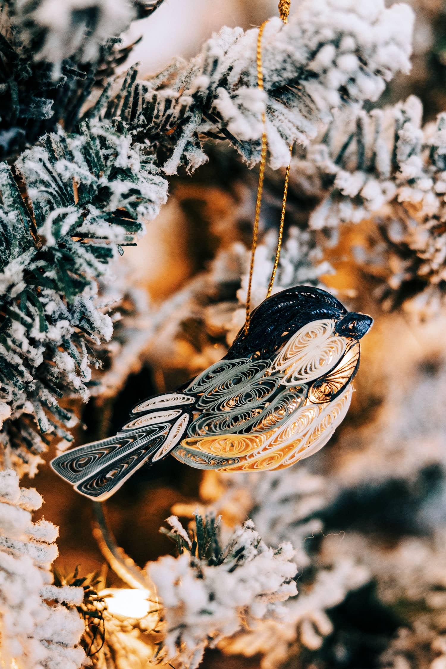 Decorative bird ornament hanging on a frosted branch