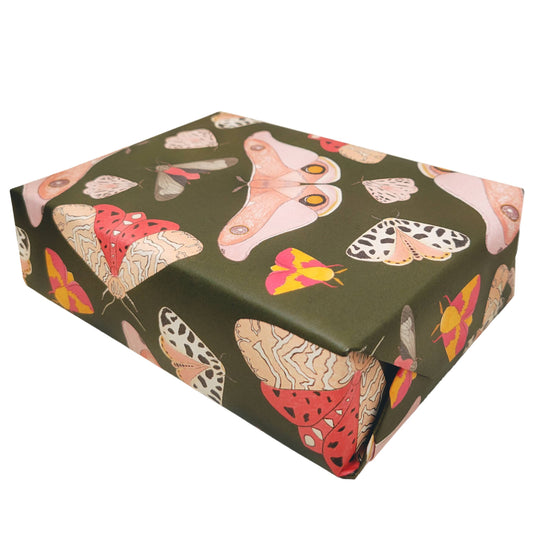 Pink moths decorate a dark craft paper making this irresistible moth gift wrap paper for all fall gifts on a white background 