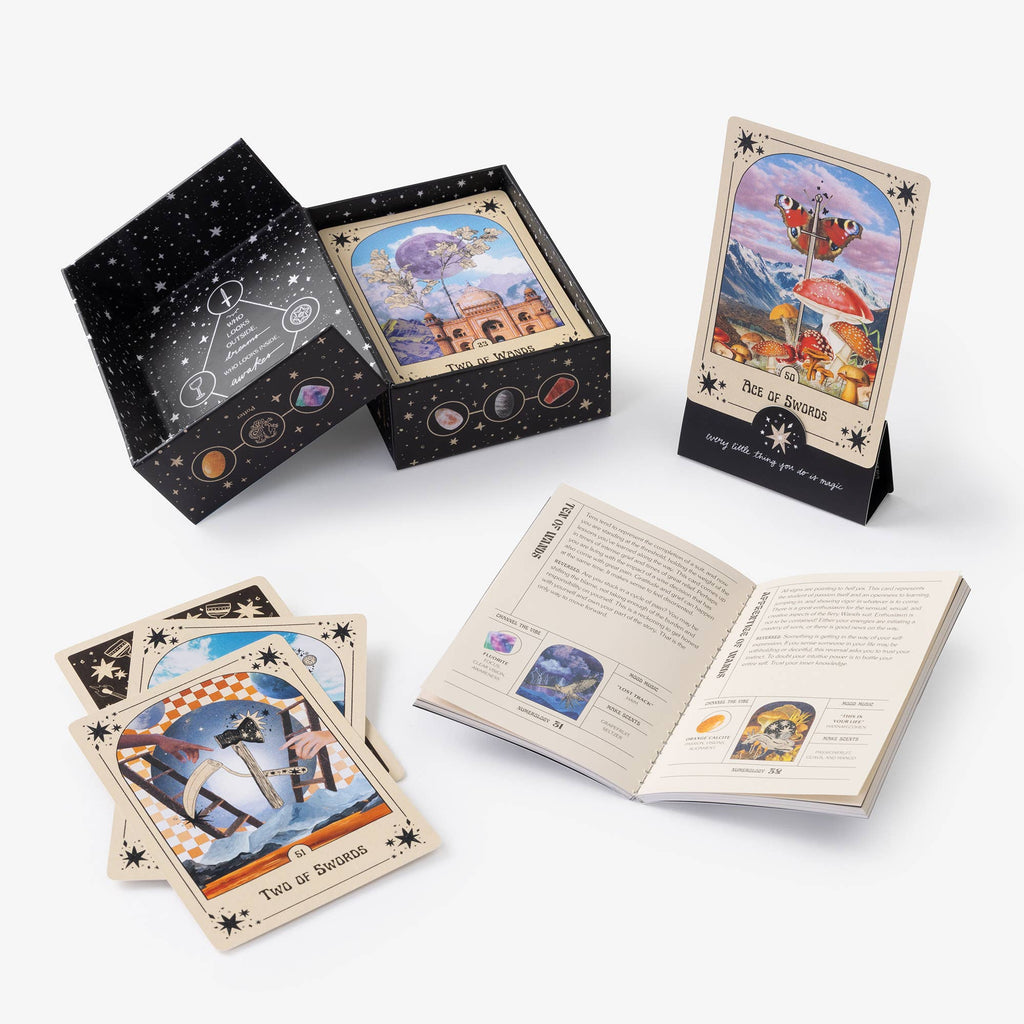 Set of tarot cards with a deck, box, and open book on a white background