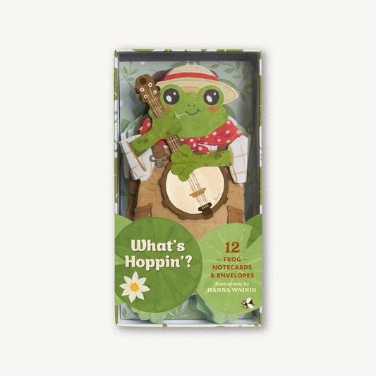 Flat lay of whimsical frog-shaped notecards with wizard, cowboy, romantic, and bookworm designs