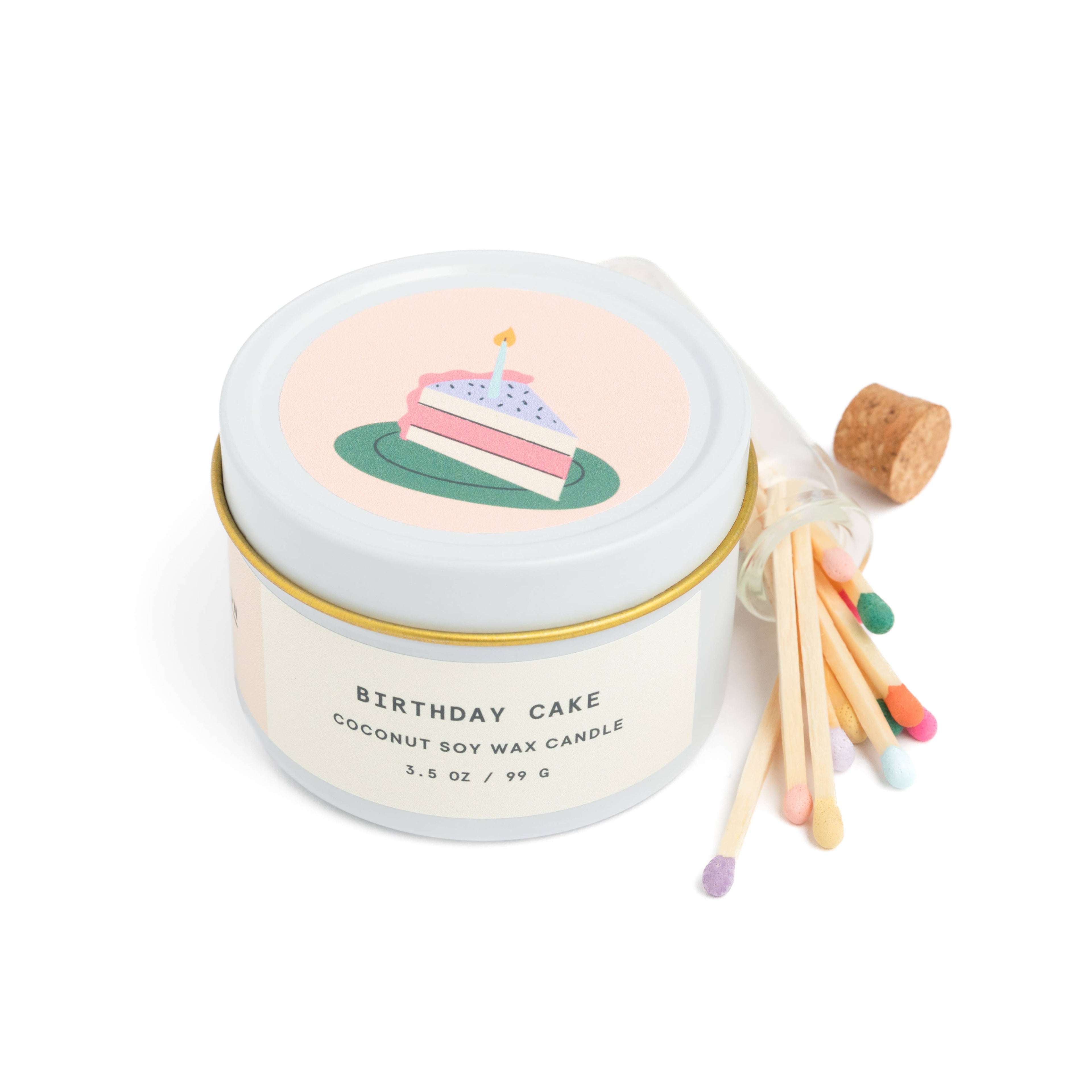 Birthday cake scented candle in white tin with corked vial of colorful matchsticks, packaged in a clear vinyl gift box.
