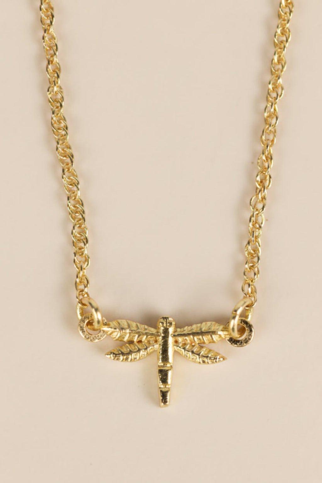 Close-up of brass dragonfly pendant on 15-inch chain, handcrafted by artisans