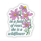Sticker with pink flowers and text 'in a field of roses, she is a wildflower' on a white background