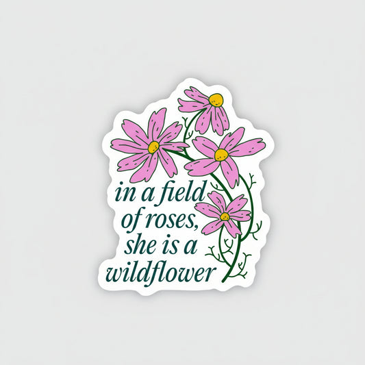 Sticker with pink flowers and text 'in a field of roses, she is a wildflower' on a white background