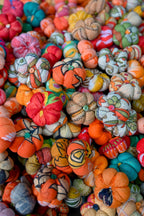 Colorful fabric pumpkins and gourds with intricate patterns.
