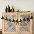 Holly Jolly Trees Crochet Garland draped across a buffet with other festive ornaments and decor with a neutral holiday background