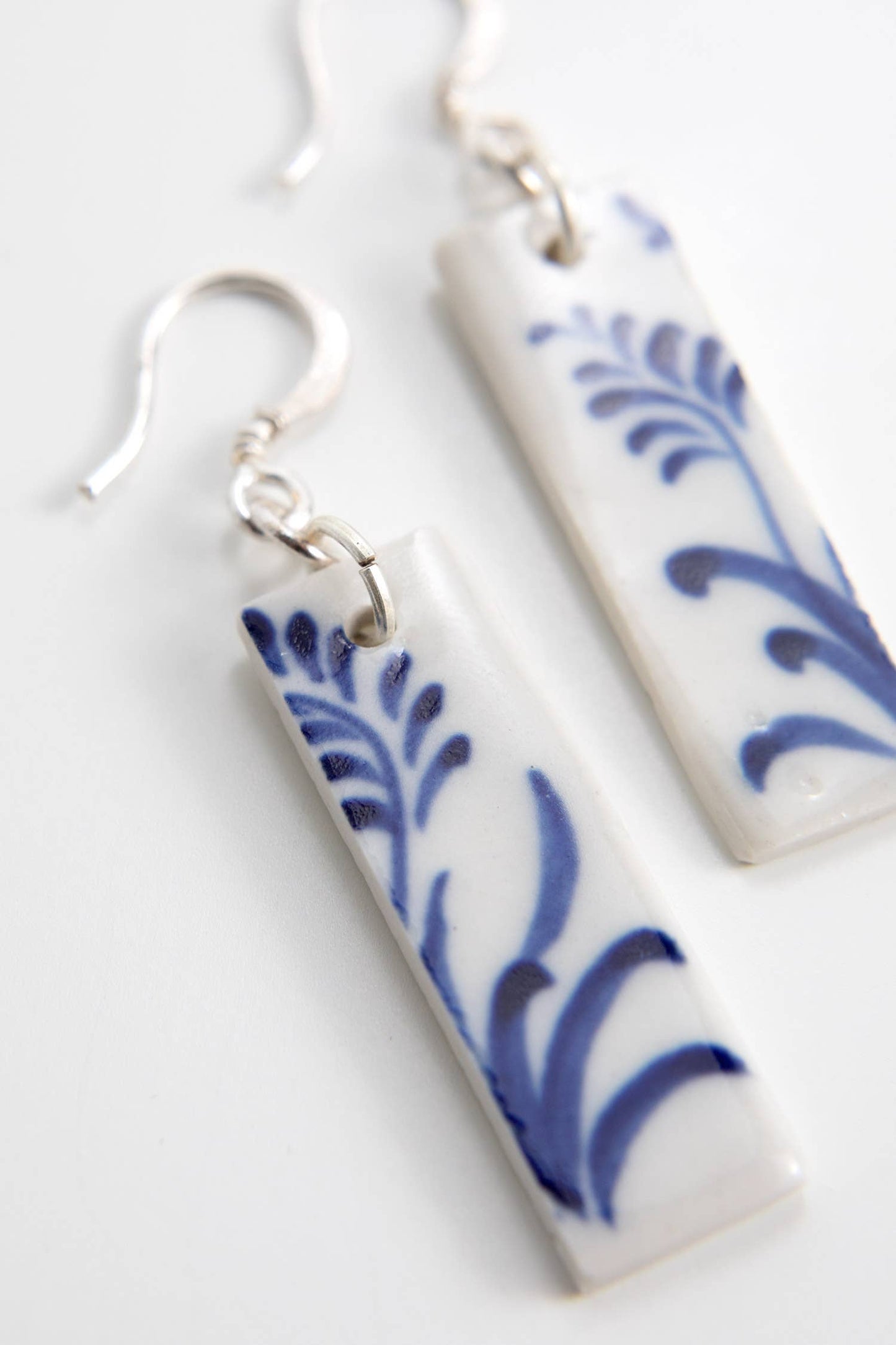 Close-up of Bat Trang ceramic earrings with French hooks and unique floral motifs