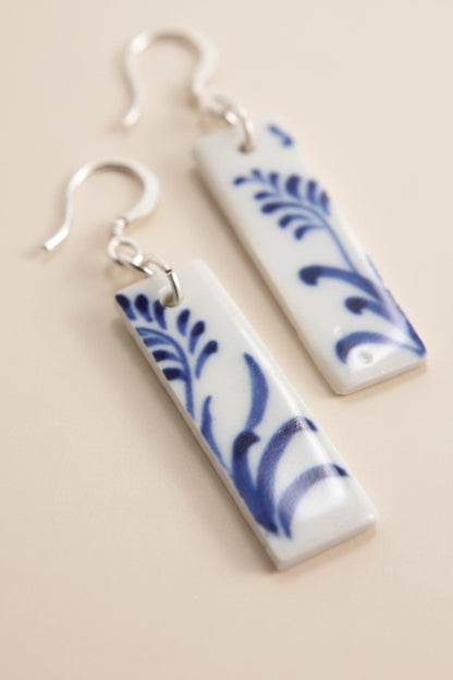Close-up of Bat Trang ceramic earrings with French hooks and unique floral motifs