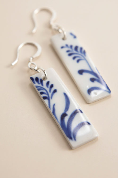 Close-up of Bat Trang ceramic earrings with French hooks and unique floral motifs