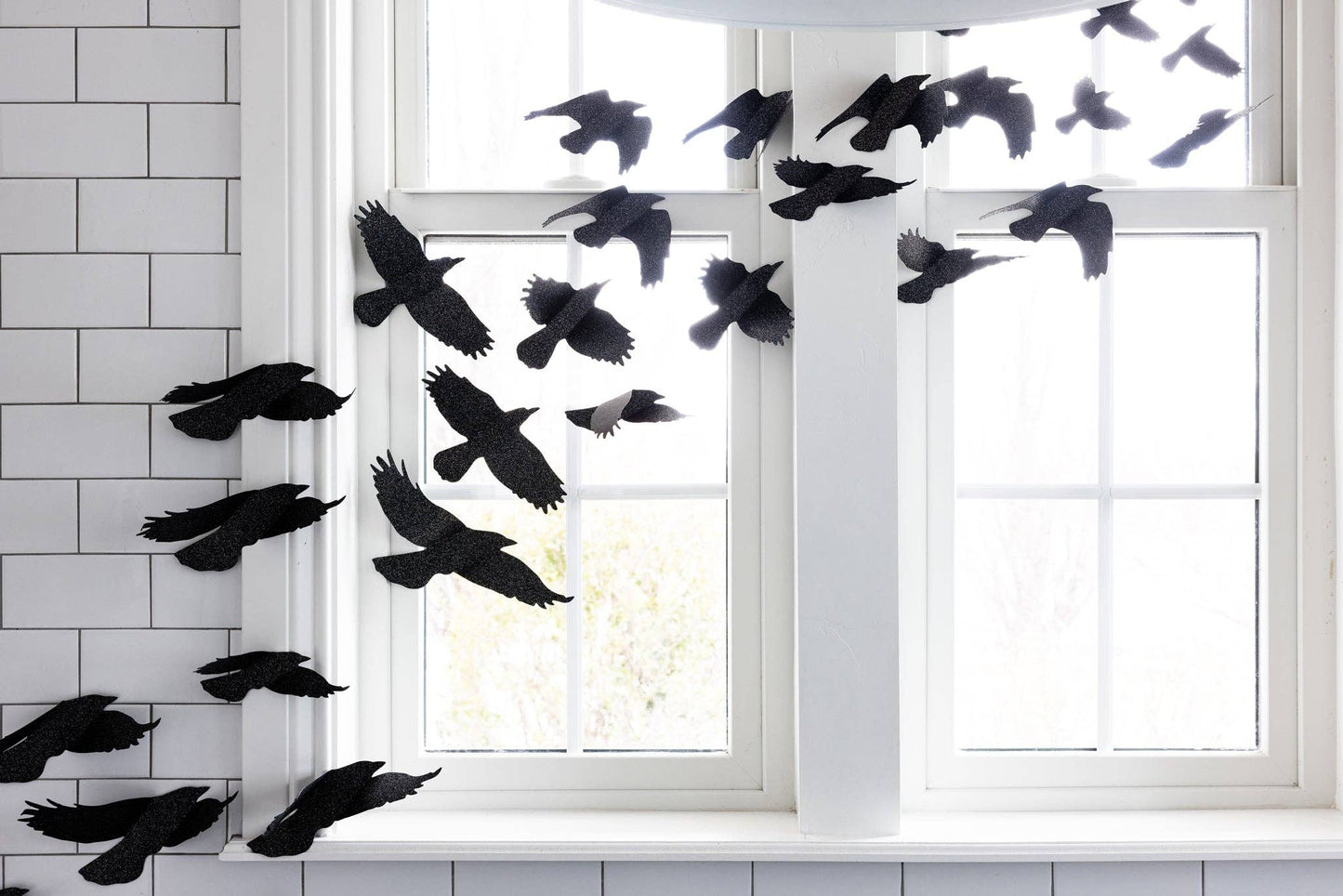 A dramatic flock of glittered black ravens flying across a Halloween wall