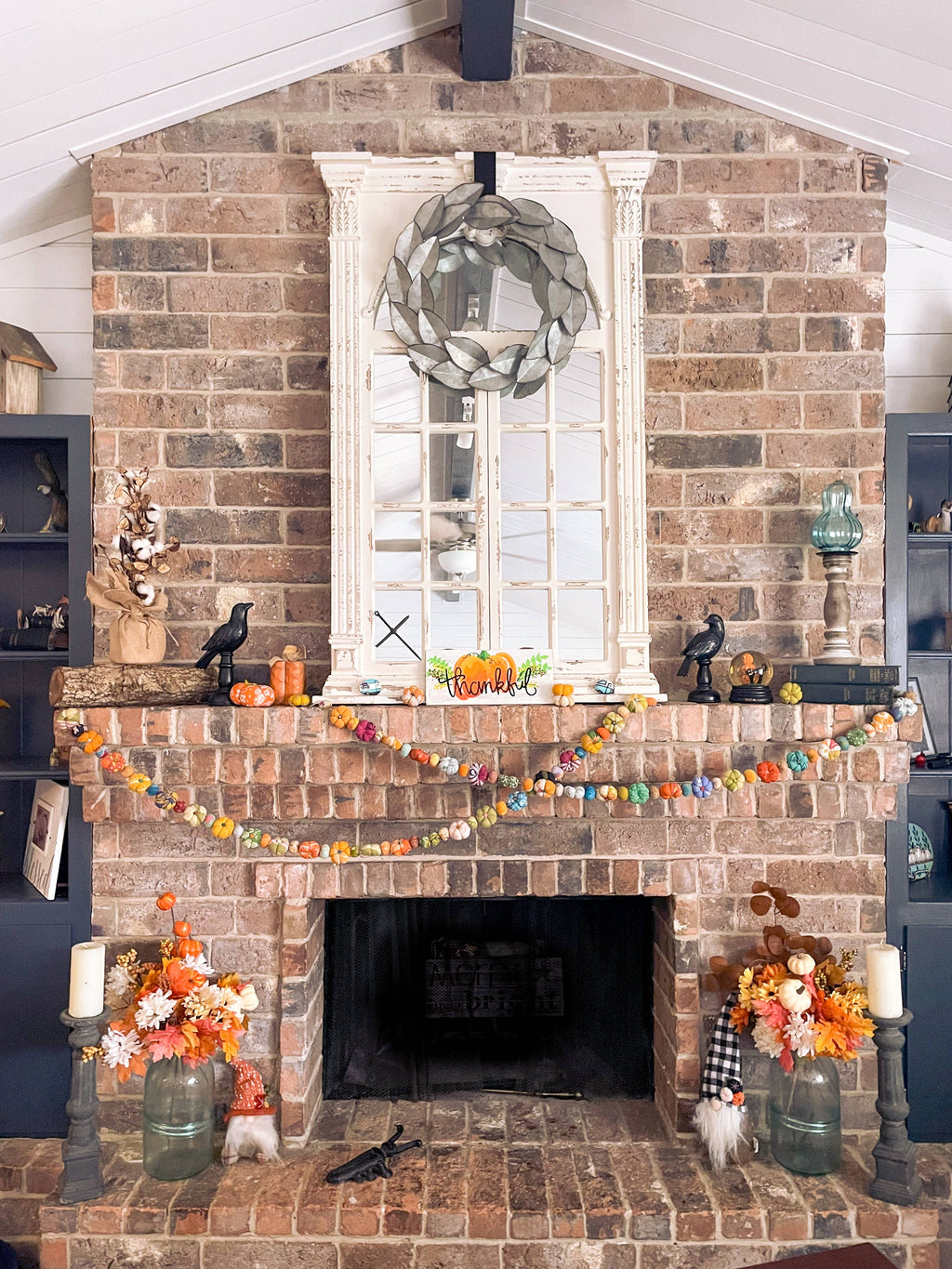Garland styled across a mantel with fall foliage and cozy candles