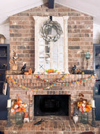 Garland styled across a mantel with fall foliage and cozy candles