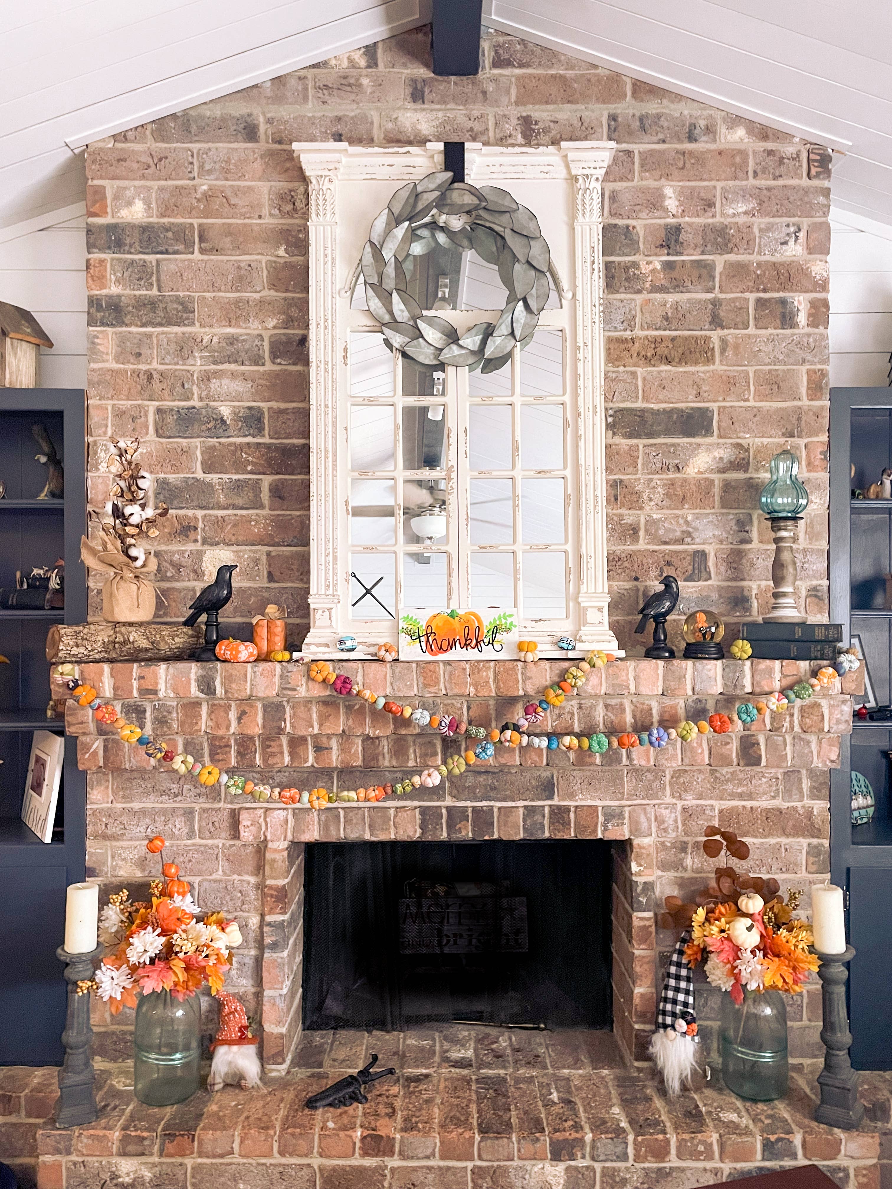 Garland styled across a mantel with fall foliage and cozy candles