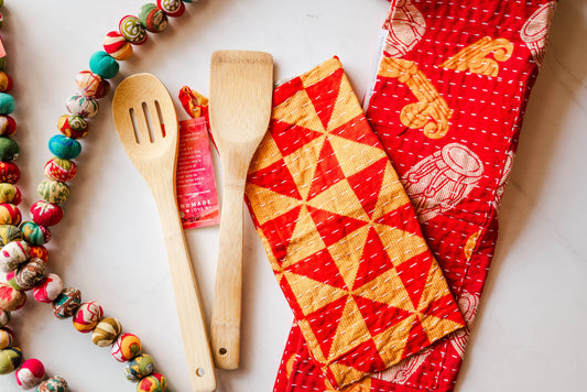 Wooden utensils and colorful fabric with geometric patterns on a light background