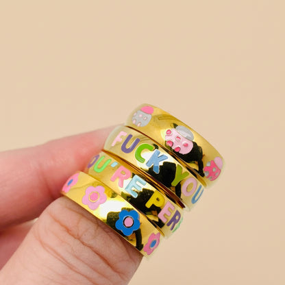Gold rings with colorful text and designs on a white background