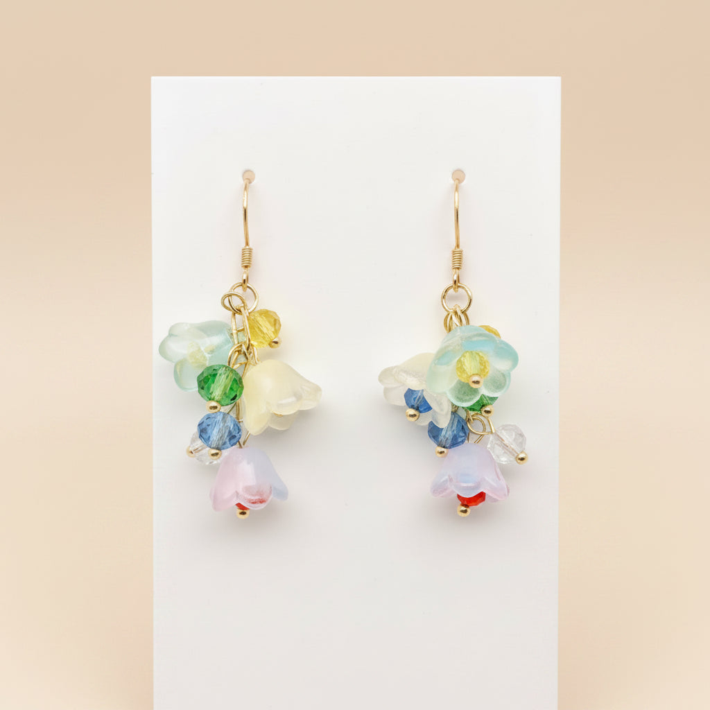 Colorful floral earrings on a white stand with a light gray background