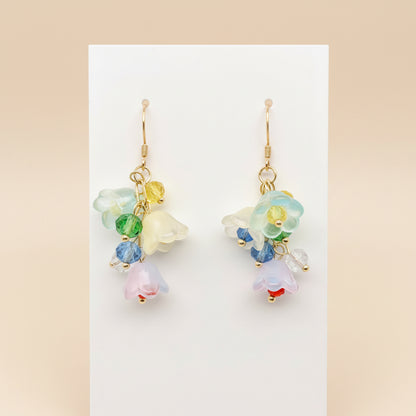 Colorful floral earrings on a white stand with a light gray background