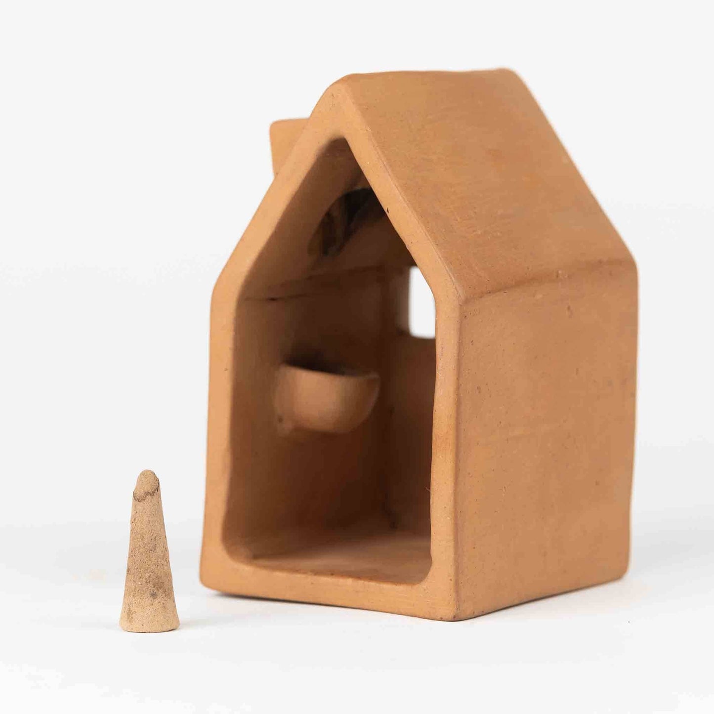 Terracotta incense house with a cone-shaped incense (not included) on a white background