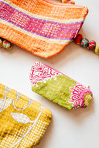 Three colorful fabric pouches on a light background