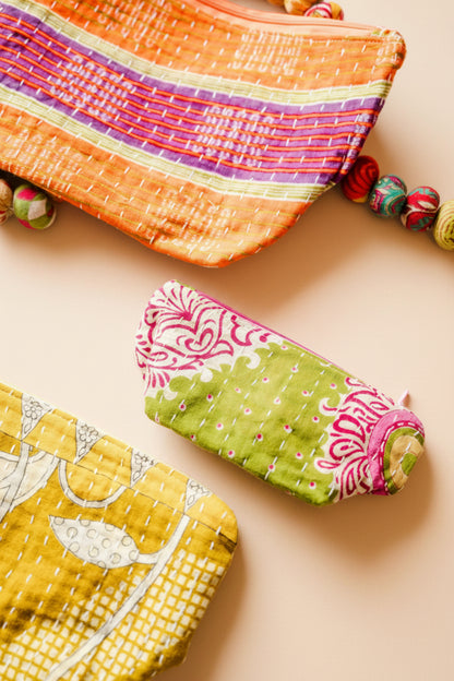 Three colorful fabric pouches on a light background