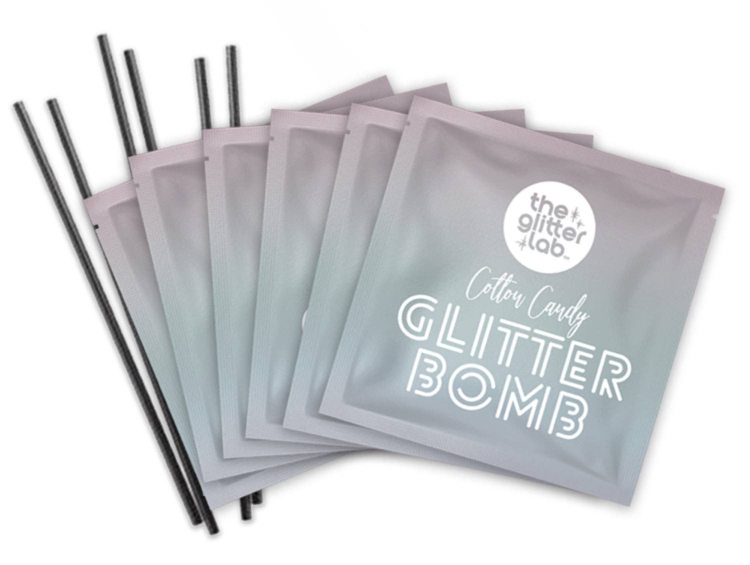 Close up of 5 Rainbow Glitter Bomb packets with stir sticks included in every box.