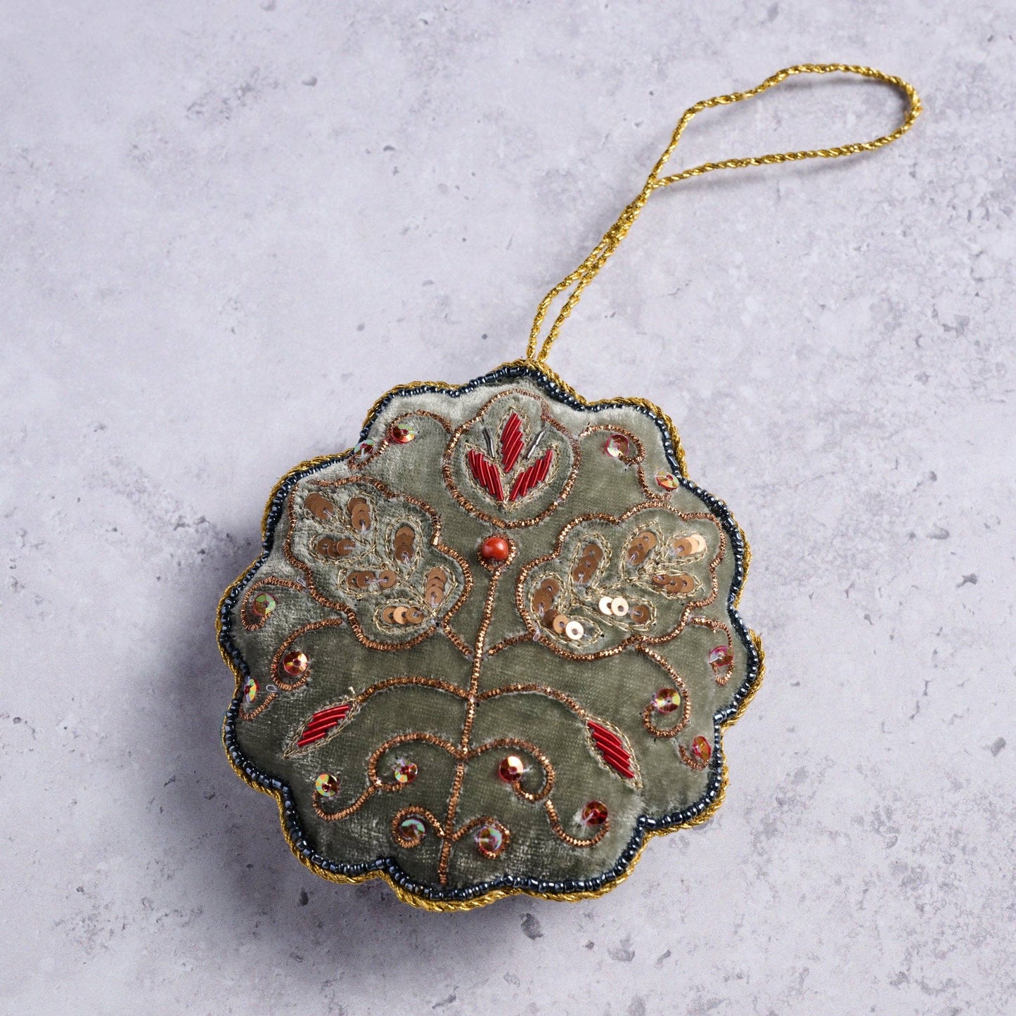 View of the Modern Victorian Embroidered Ornament laying on a marble countertop