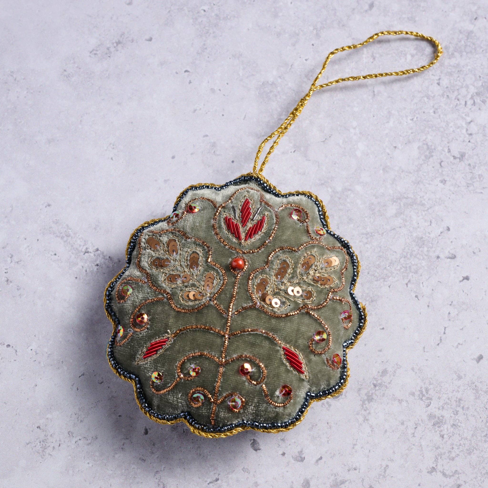 View of the Modern Victorian Embroidered Ornament laying on a marble countertop