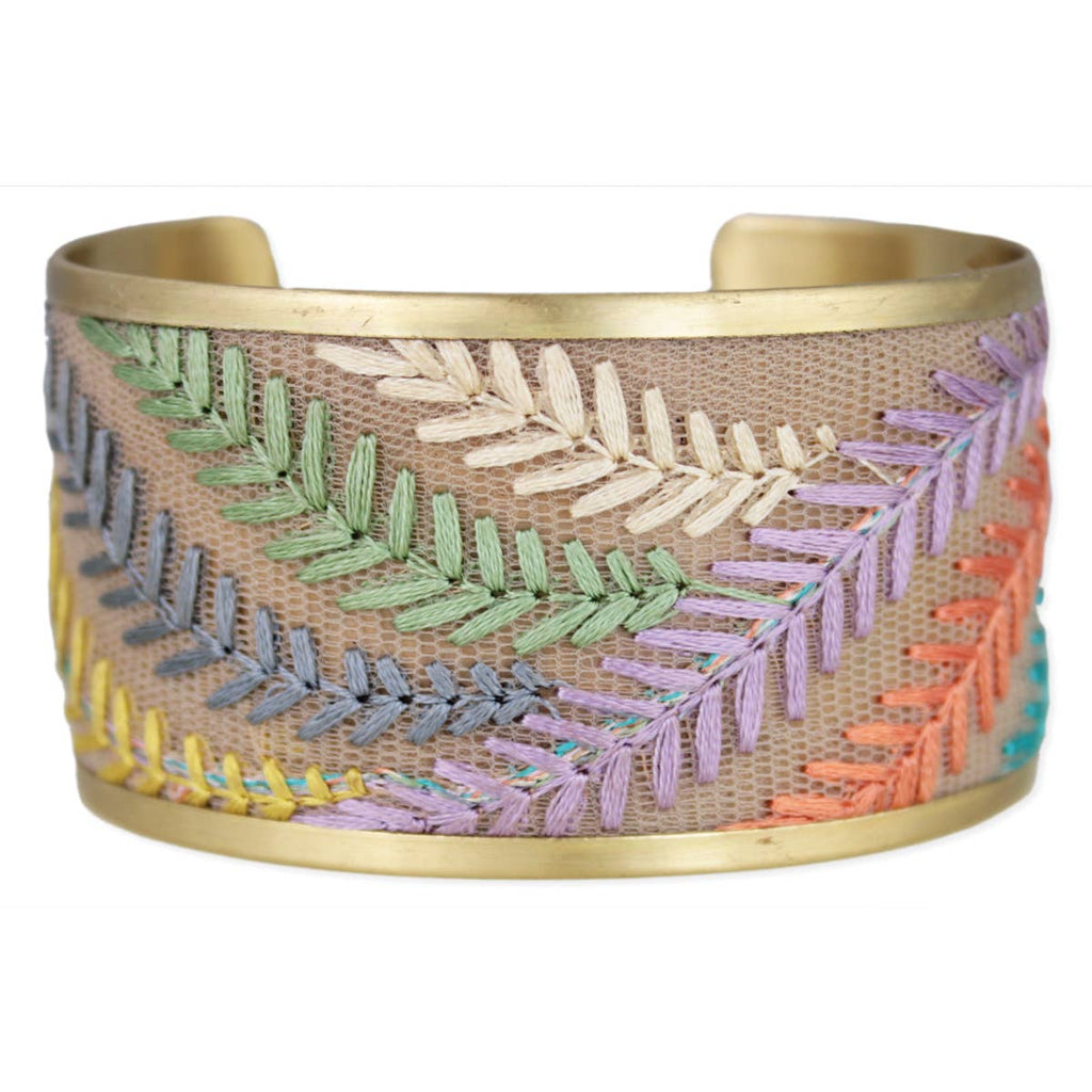 Wide gold bracelet with colorful embroidered leaves on a white background