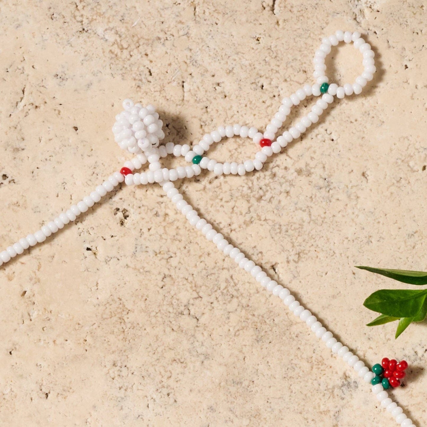 Close-up of artisan-crafted Taja necklace featuring a playful strawberry design and seamless ball-and-eye closure
