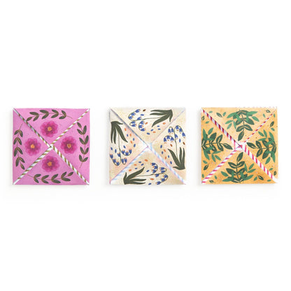 Three square coasters with floral designs on a white background