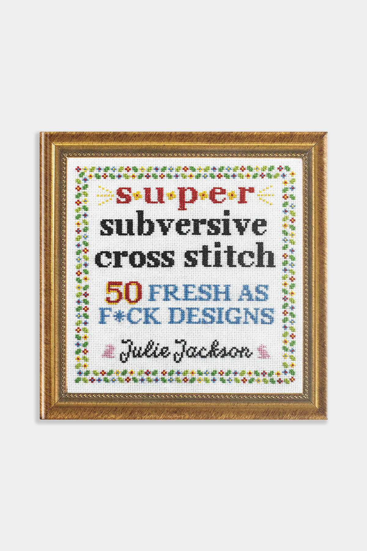 Framed cross-stitch pattern with colorful text on a white background