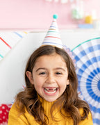 Image of child at party wearing bright and colorful hat with gold accents