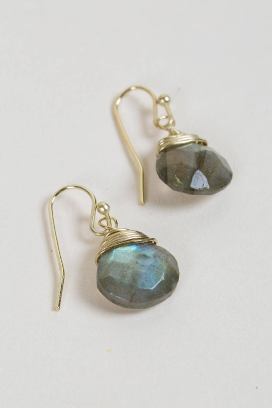 Close-up of faceted labradorite earrings wrapped in matte gold wire