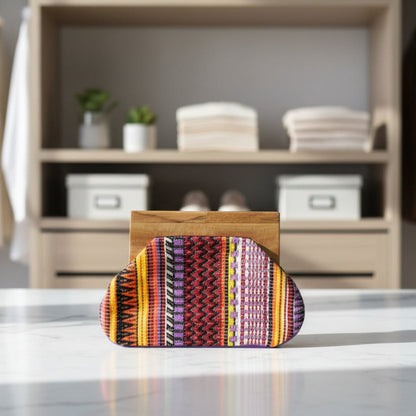 Colorful patterned pouch on a wooden block against a white background