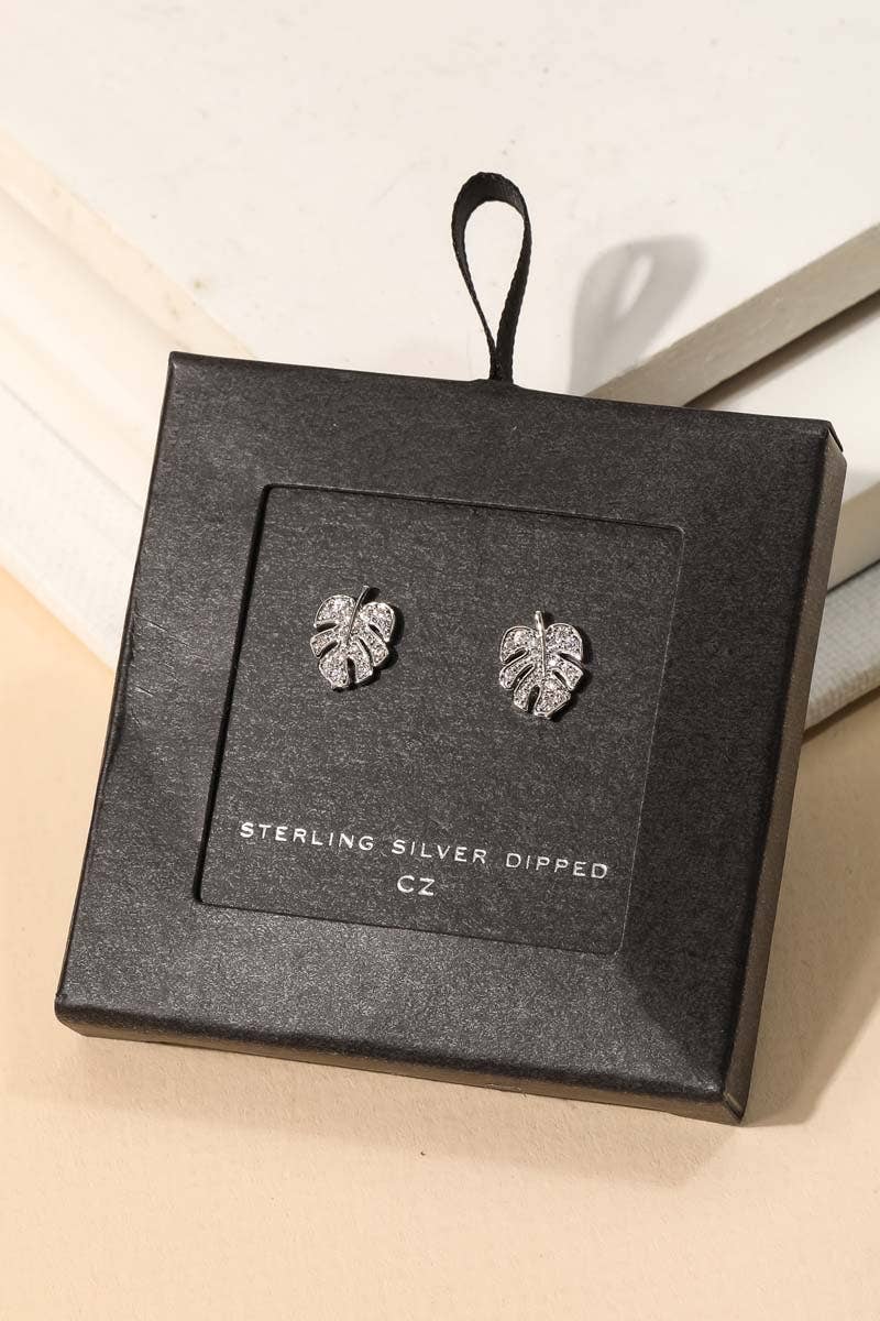 Close-up of white gold dipped monstera leaf stud earrings