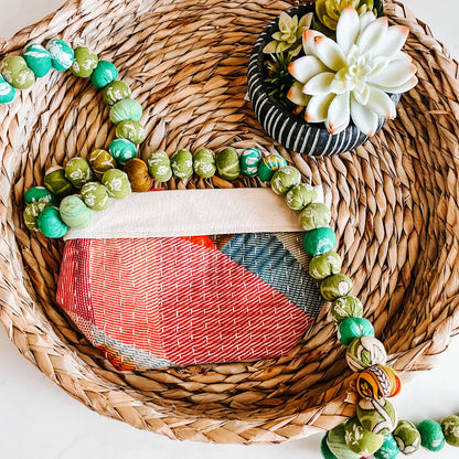 Decorative wreath with beads and succulent on a woven mat showcasing one of the bags